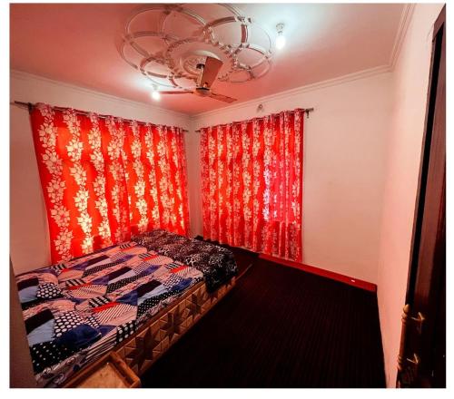 um quarto com uma cama e uma cortina vermelha em THE Q2 RESIDENCY em Srinagar