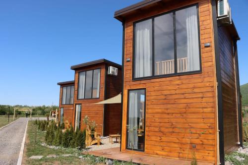 a wooden house with large windows on a road at Natura Bungalow in Ždrelo
