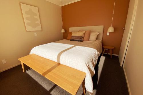 a small bedroom with a bed and a wooden table at Pohara's Beach House in Pohara