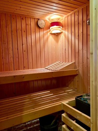 a sauna with a clock on a wooden wall at Landhaus de Gaspary in Seehausen am Staffelsee