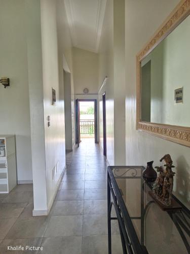 a hallway with a glass table and a mirror at Résidence cœur de Marie in Abomey-Calavi