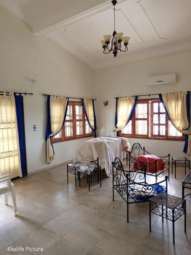 a room with chairs and a table and windows at Résidence cœur de Marie in Abomey-Calavi