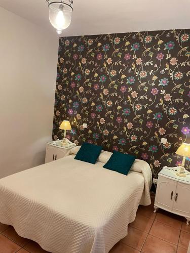 a bedroom with a bed with a floral wallpaper at Apartamentos Turisticos La vida de antes in Consuegra