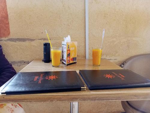 uma mesa com dois computadores portáteis e dois copos de sumo de laranja em Sunciti Resort Sagana 