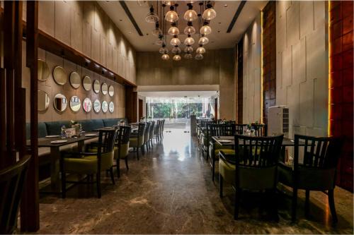 een eetkamer met stoelen en tafels en een kroonluchter bij Hotel Care Holiday Banjara- a Luxury Collection Hotel- An Svm Hotel in Hyderabad