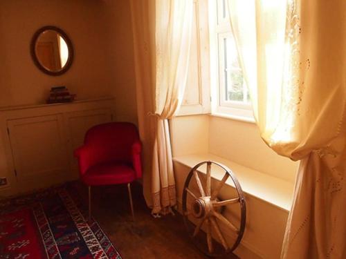 um quarto com uma cadeira vermelha e uma janela em Truck House, Luxury accommodation, pet friendly em Truro