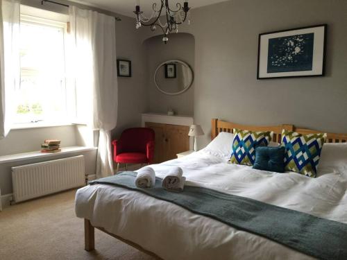 a bedroom with a bed with a red chair and a window at Truck House, Luxury accommodation, pet friendly in Truro