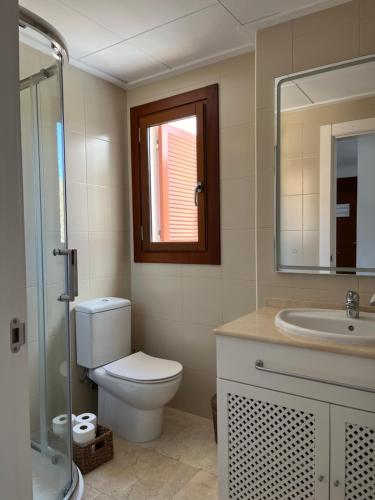 a bathroom with a toilet and a sink and a mirror at El Valle Golf Resort in Baños y Mendigo