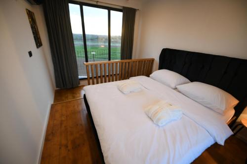 a bedroom with a white bed with two towels on it at Natura Bungalow in Ždrelo