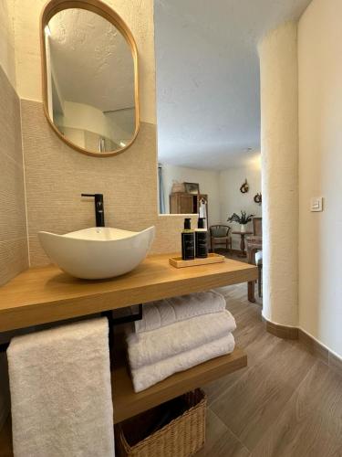 a bathroom with a sink and a mirror and towels at HOTEL RURAL SANTUI in Horcajuelo de la Sierra