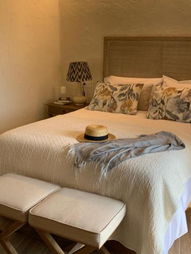 a bedroom with a bed with a hat on it at HOTEL RURAL SANTUI in Horcajuelo de la Sierra