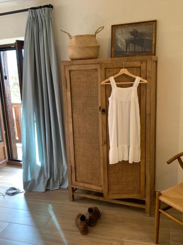 a wooden cabinet with a white dress hanging on it at HOTEL RURAL SANTUI in Horcajuelo de la Sierra