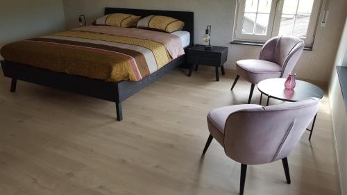 1 dormitorio con 1 cama, mesa y sillas en B&B Krieken de Jour, en Ninove