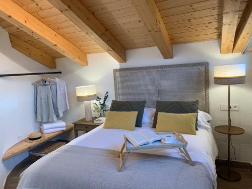 1 dormitorio con 1 cama grande y 2 libros. en HOTEL RURAL SANTUI, en Horcajuelo de la Sierra