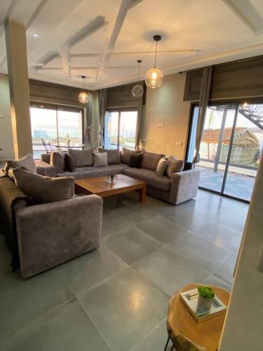 a large living room with couches and a table at Ezz’Dar HOME II in Asilah