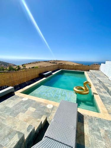 a swimming pool with a gold snake in it at Ezz’Dar HOME II in Asilah