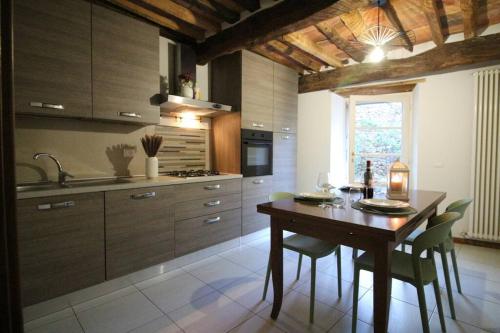 a kitchen with a wooden table with chairs and a sink at Borgo dei vigneti in Montecarlo