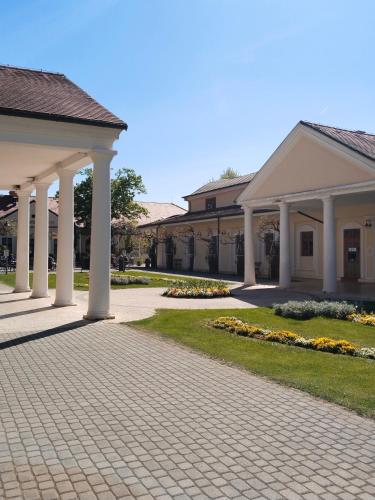 a building with white columns and a walkway at Leier apartments in Piešťany
