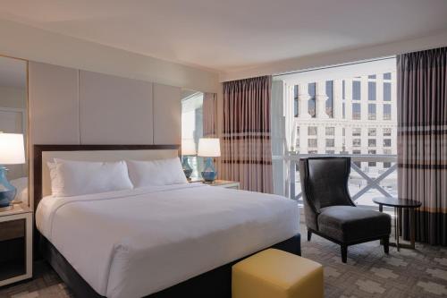 a hotel room with a bed and a chair at Caesars Palace Hotel & Casino in Las Vegas