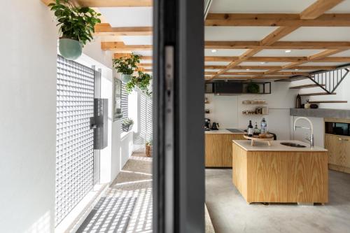 an open kitchen with wooden cabinets and a kitchen island at Urban Loft in Porto
