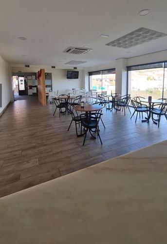 a large room with tables and chairs and windows at Hospedería municipal la cultural in Saucelle