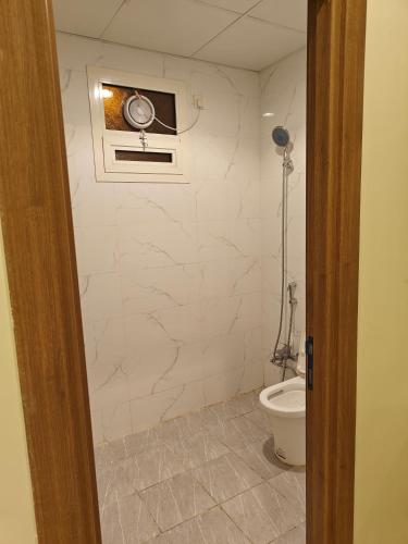 a bathroom with a toilet and a window on the wall at حي المطار King Khalid Airport Community Apartment in Riyadh