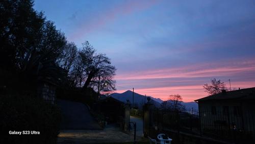 a sunset in a city with a fence and trees at Galbanera turismo in Albavilla