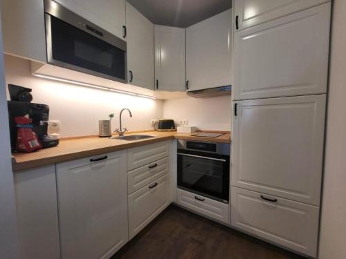 a kitchen with white cabinets and a sink and a refrigerator at Landliebe - b48899 in Stein