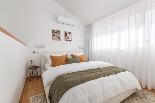 - une chambre blanche avec un lit et une fenêtre dans l'établissement Urban Loft, à Porto