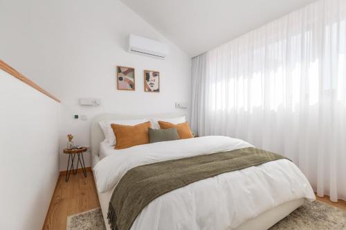 a white bedroom with a bed and a window at Urban Loft in Porto