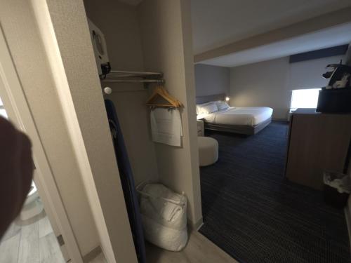a hotel room with a bedroom with two beds and a hallway at Wingate by Wyndham Waynesboro in Waynesboro
