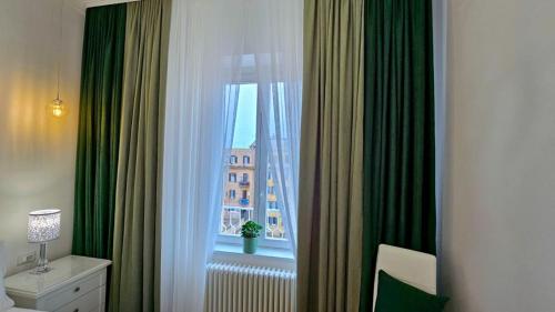une pièce avec une fenêtre avec des rideaux verts dans l'établissement Val's Vatican Wall Apartment, à Rome