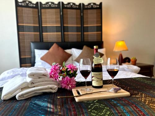 a bed with two glasses of wine and towels and flowers at 350 METER BEACH , Center of the City in Hua Hin