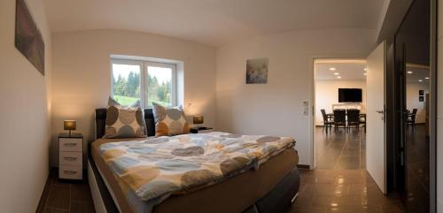 Un dormitorio con una cama grande y una ventana en Moderne-barrierefreie-Ferienwohnung en Buchenberg