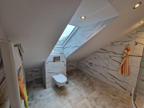 een badkamer met een toilet op zolder bij Apartament KNIEJA LUX in Tuchola