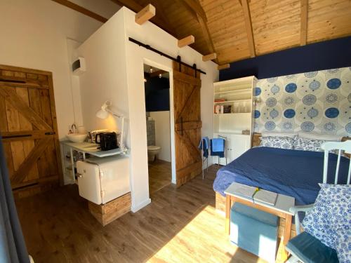 ein Schlafzimmer mit einem Bett und ein Badezimmer mit einem Waschbecken in der Unterkunft B&B by Mo in Etyek