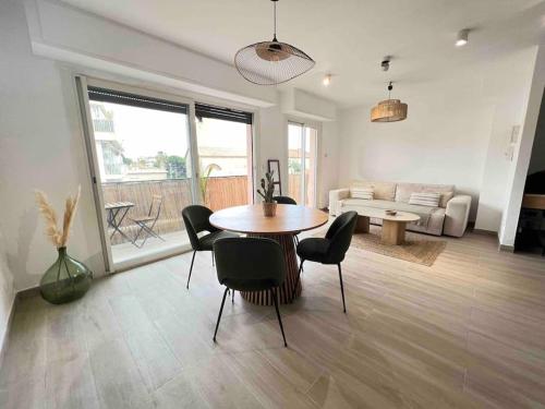 ein Wohnzimmer mit einem Tisch, Stühlen und einem Sofa in der Unterkunft T2 tout confort proche plage in Antibes