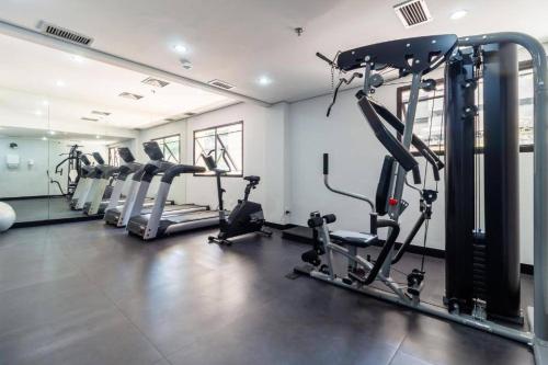 a gym with several tread machines in a room at Flat VI - Quarto particular dentro do Hotel (WTC) in São Paulo