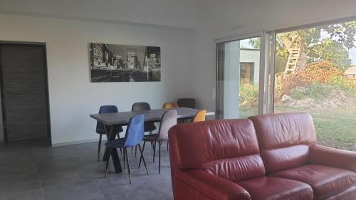 uma sala de estar com um sofá, uma mesa e cadeiras em CHAMBRE MEUBLEE LIT 2 PERSONNES em Le Poiré-sur-Vie