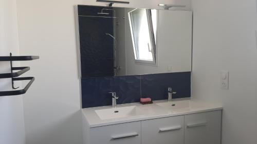 a bathroom with two sinks and a mirror at CHAMBRE MEUBLEE LIT 2 PERSONNES in Le Poiré-sur-Vie