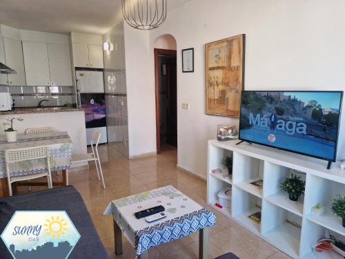 a living room with a tv and a kitchen at Sunny Churriana-Airport in Málaga