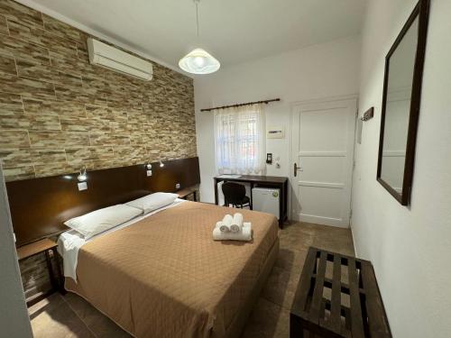 a bedroom with a bed and a desk in it at Eleni Rooms in Rhodes Town