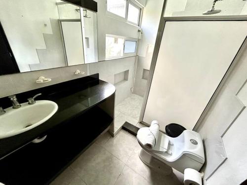 ein Bad mit einem Waschbecken, einer Dusche und einem WC in der Unterkunft Fantastico Duplex Familiar con AC Wifi & Alberca #1 in Mérida