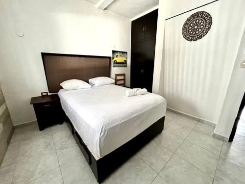 ein Schlafzimmer mit einem großen Bett in einem Zimmer in der Unterkunft Fantastico Duplex Familiar con AC Wifi & Alberca #1 in Mérida