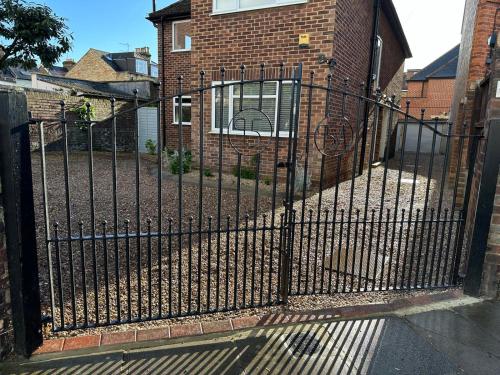 a black fence in front of a brick house at Large 2-bedroom maisonette with free parking in Twickenham