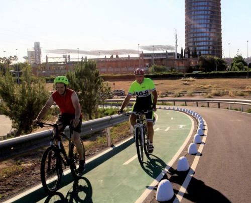 dos hombres montando bicicletas en una carretera en Habitación en Sevilla dias/semana, en Camas