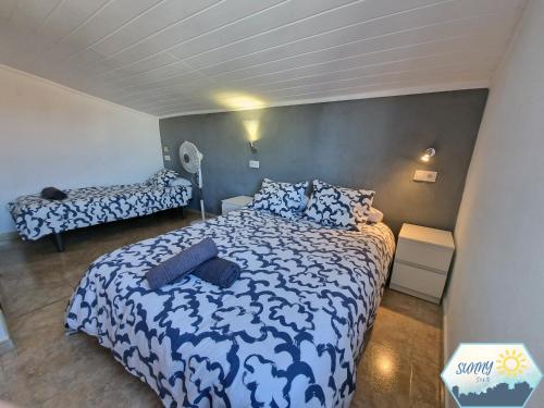 Schlafzimmer mit einem Bett mit einer blauen und weißen Bettdecke in der Unterkunft Sunny Churriana Airport III in Málaga