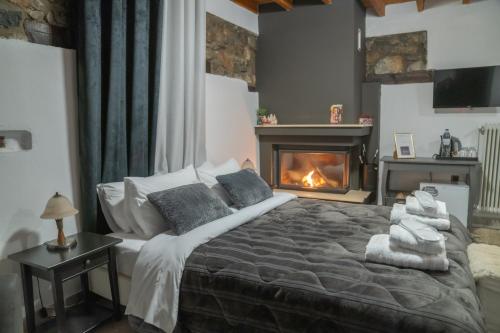 a bedroom with a large bed with a fireplace at kaimak luxury chalet in Palaios Agios Athanasios