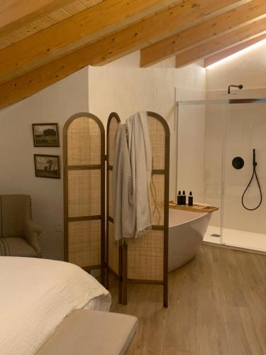 a bedroom with a tub and a bed and a bath tub at HOTEL RURAL SANTUI in Horcajuelo de la Sierra