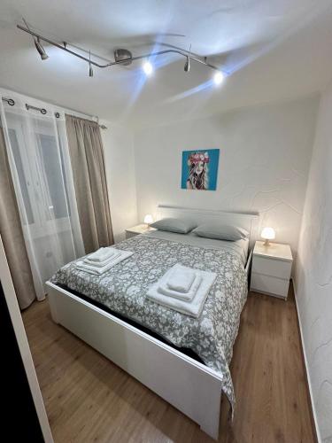 a white bedroom with a bed with two towels on it at BELLO BORGO in Taranto